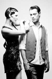 Ein Model-Foto in Schwarz-Weiß von einem sehr gut frisierten Paar. Beide haben kurze Haare, die mit Gel frisiert sind.