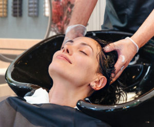 Beim KLIER Friseur im Seidnitz-Center erhält eine Kundin eine Haarwäsche.