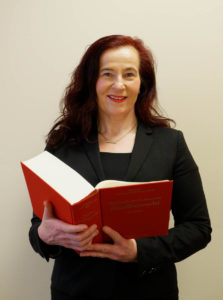 Simone Sperling hält ein aufgeschlagenes Buch.